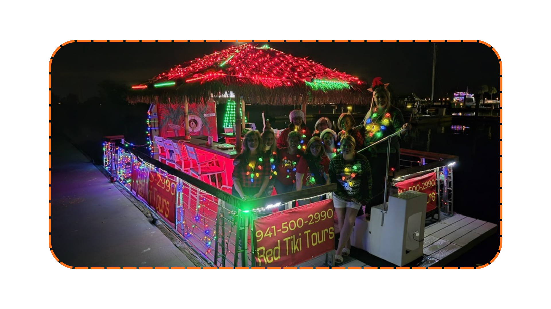 Group on decorated, lit-up tiki-themed boat at night with festive lights and signs for Red Tiki Tours.